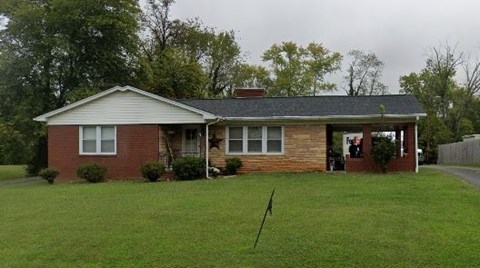 A house with a red brick exterior and a grey roof.