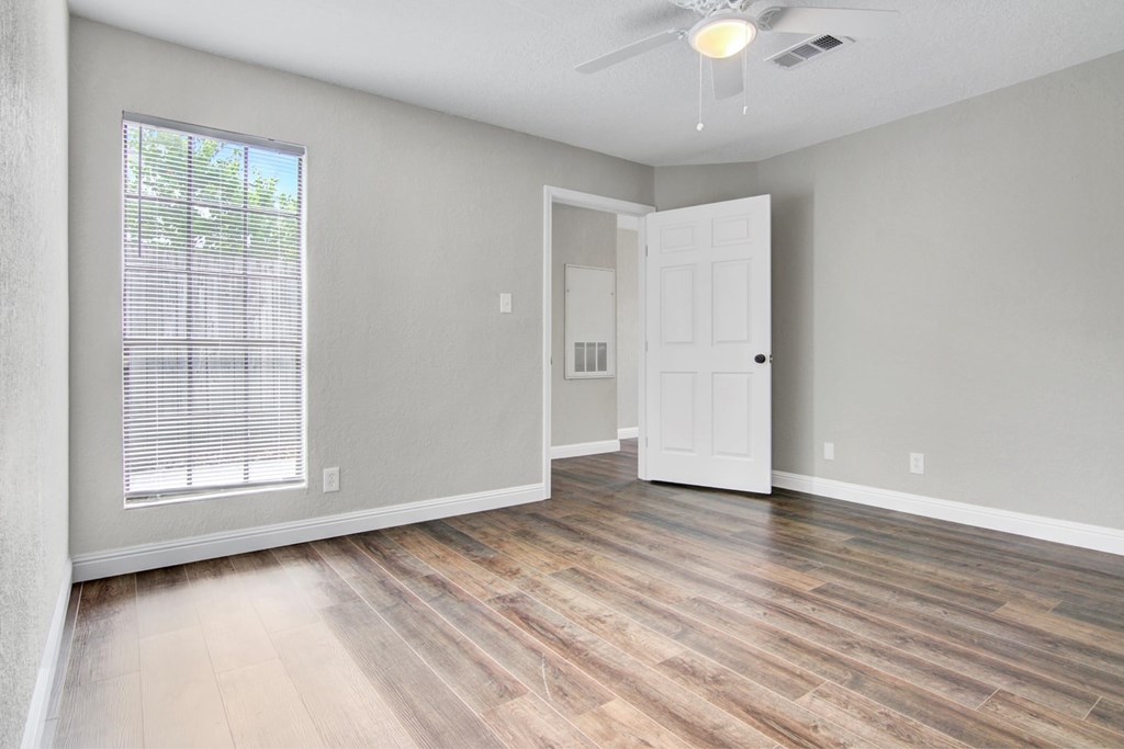 A room with a white door and a window with blinds.