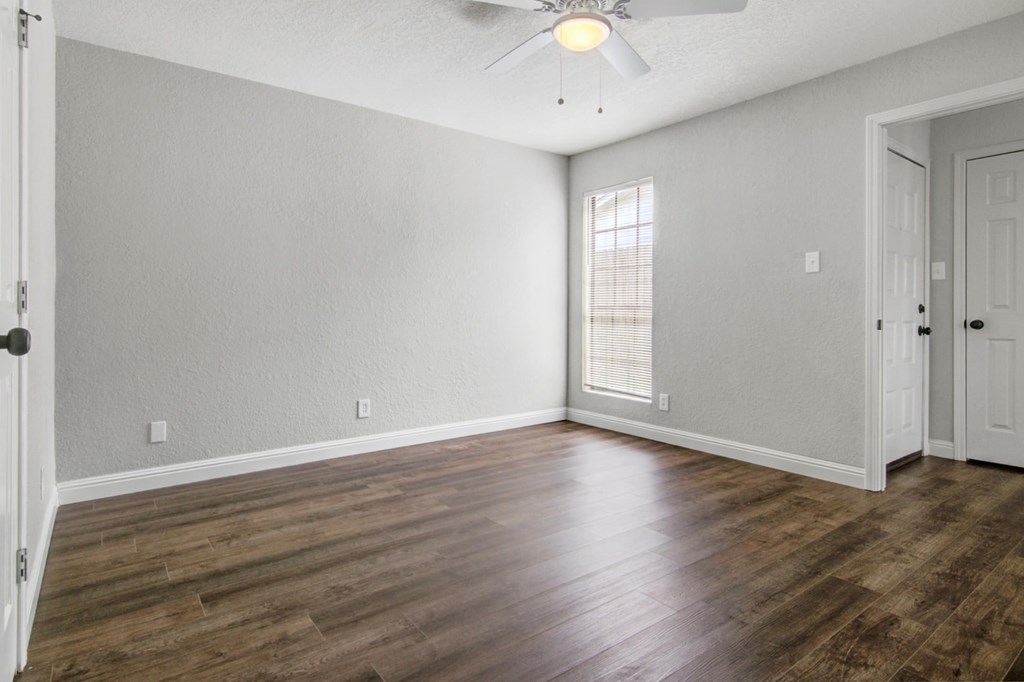 A room with wooden floors and a ceiling fan.