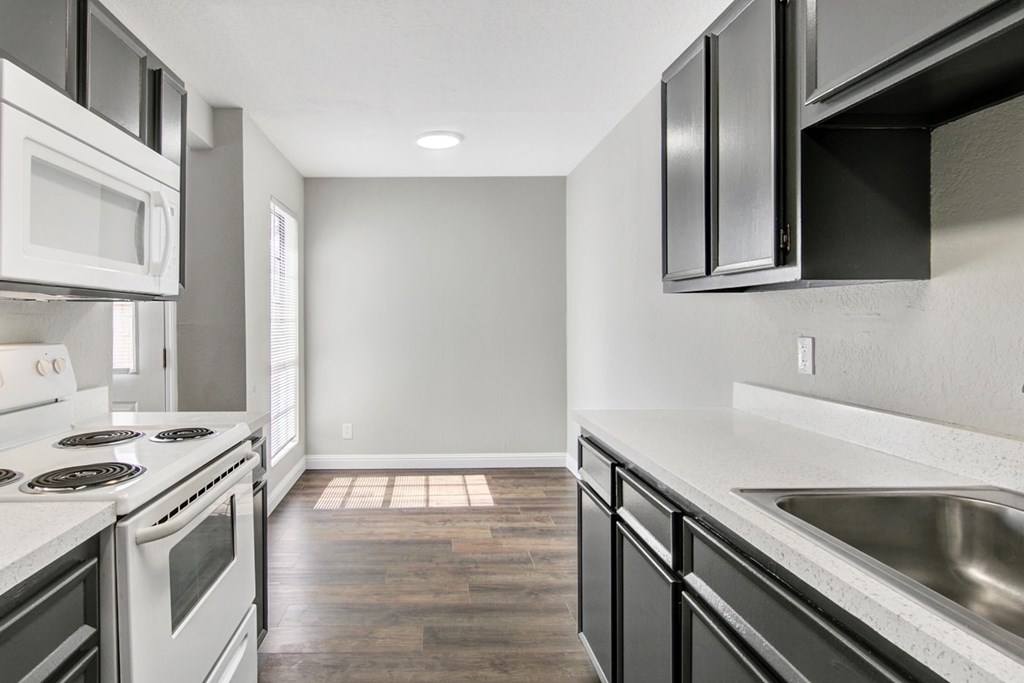 A modern kitchen with white appliances and black cabinets.