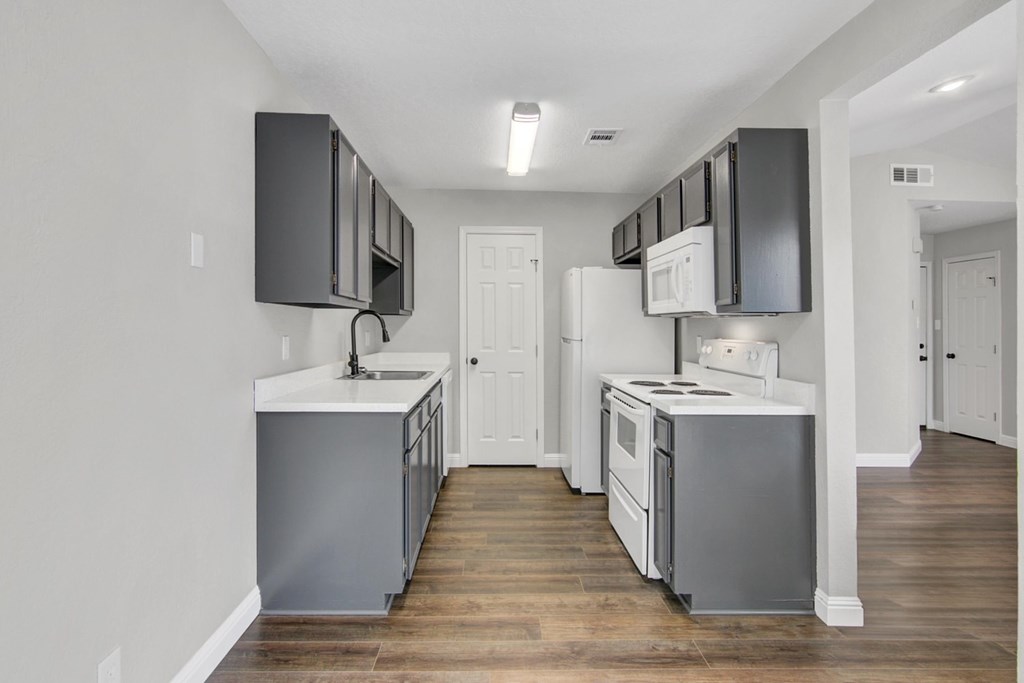 A kitchen with white cabinets and a white counter top.