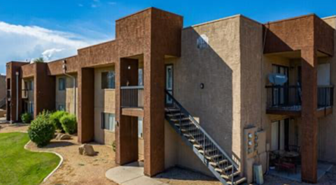 A series of brown concrete buildings with staircases leading to the second floor.