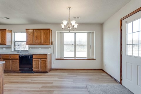 A kitchen with wooden cabinets and a black oven.