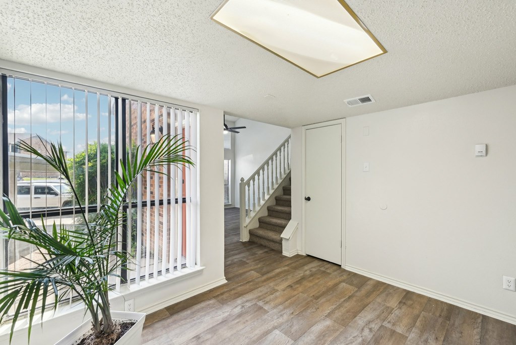A kitchen with a white stove top oven and a fan on the ceiling.