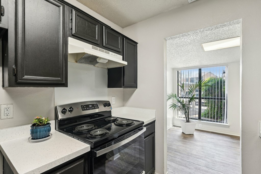 A kitchen with white appliances and black cabinets.