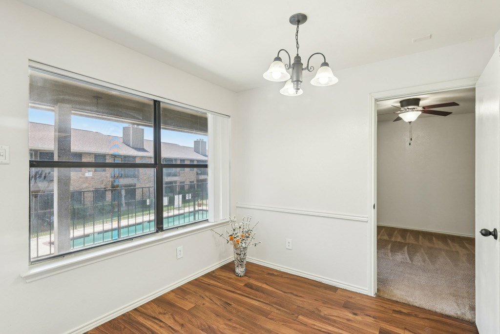 A white bathroom with a toilet, sink, and mirror.