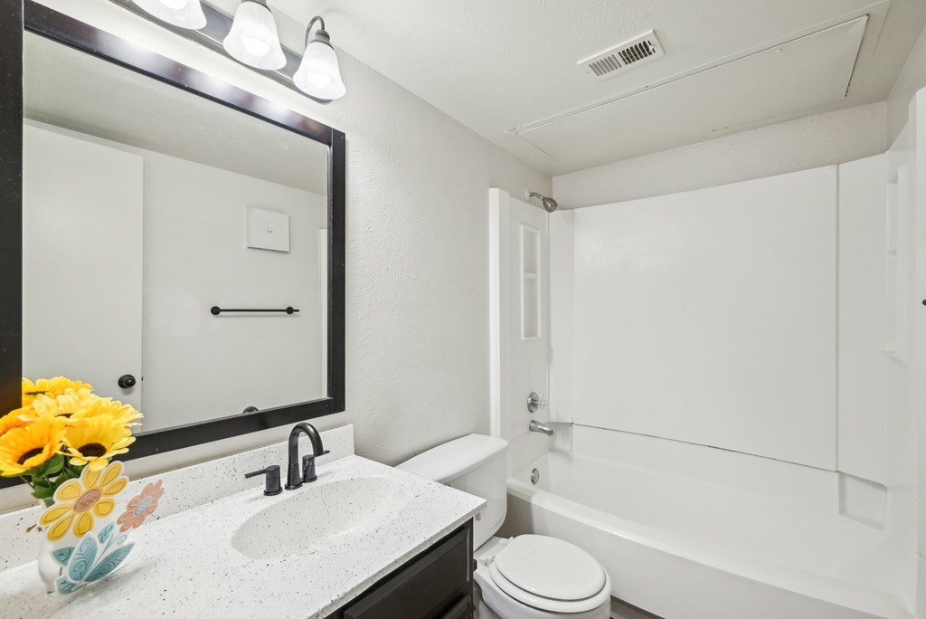 A spacious room with a ceiling fan and sliding glass doors.