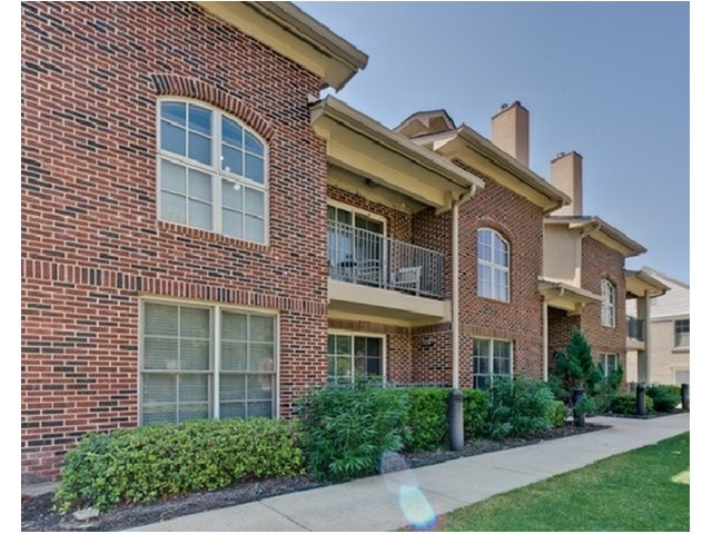 A red brick building with a balcony on the second floor.