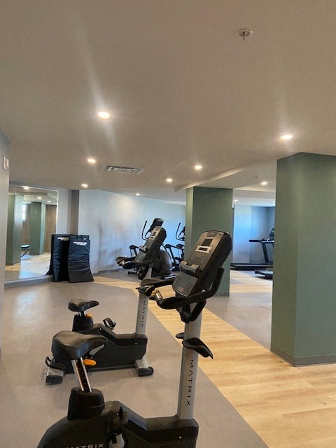 A gym with a variety of exercise equipment including treadmills, stationary bikes, and elliptical machines.