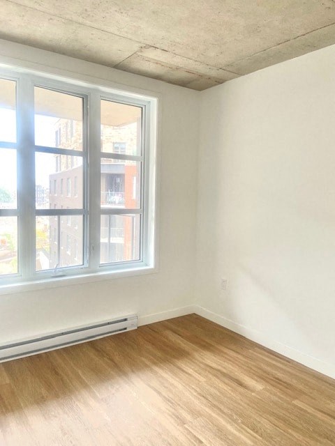 A room with a window and a radiator on the floor.