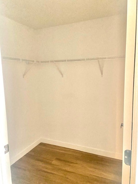 A white closet with a wooden floor and a white door.