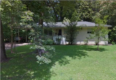 A house with a white fence and a green lawn.