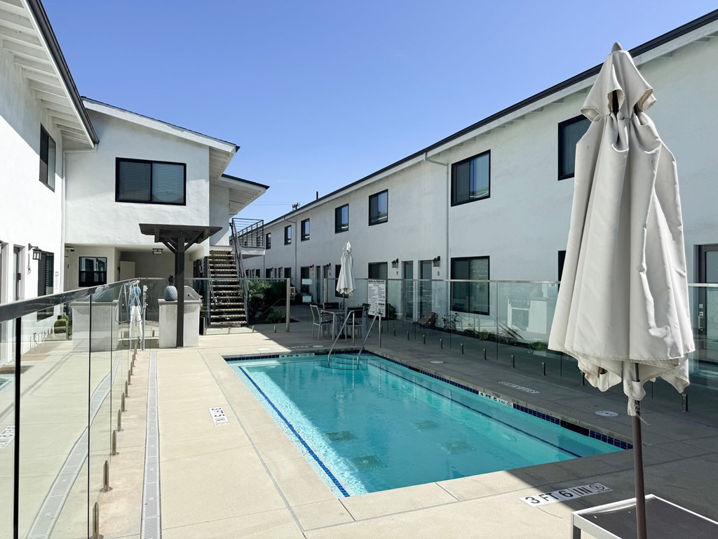 A white building with a pool in front.