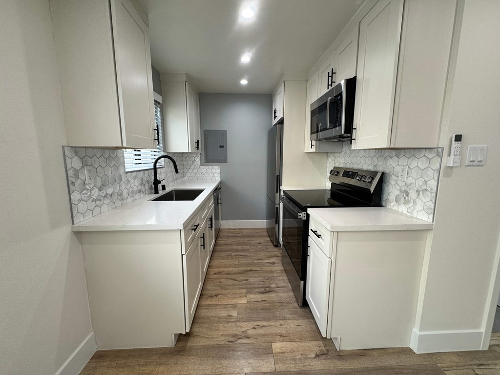 A kitchen with white cabinets and a black oven.