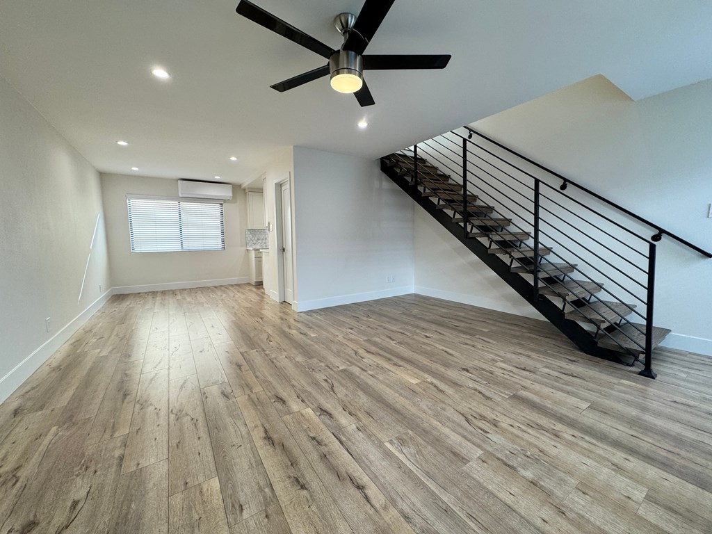A room with a staircase and a ceiling fan.