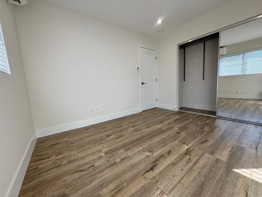 A room with wooden flooring and a sliding door.