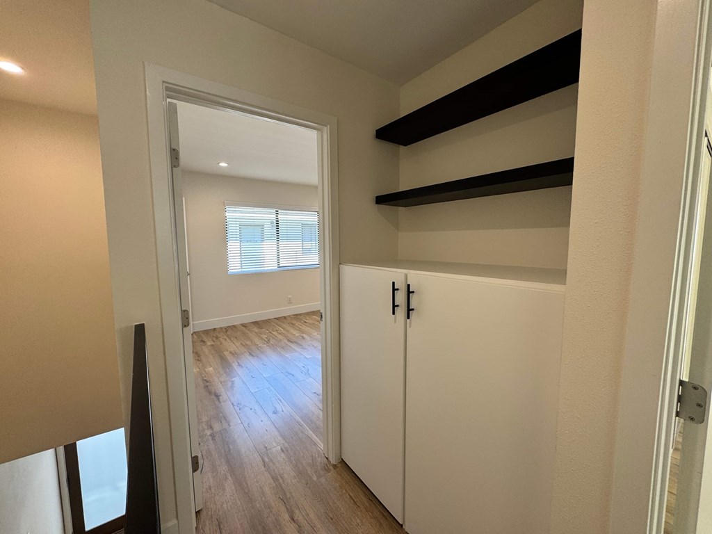 A white closet with a sliding door and a window.