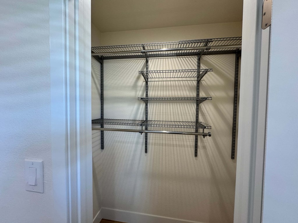 A white closet with a metal shelf.