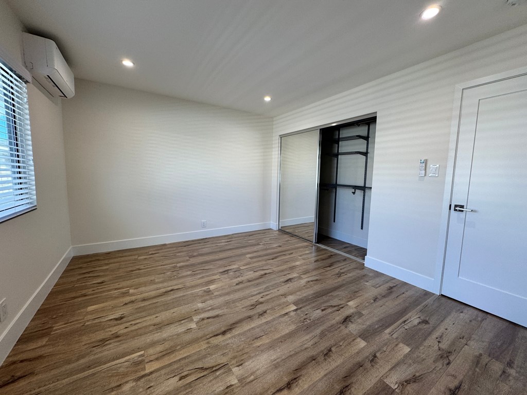 A room with wooden flooring and a white door.