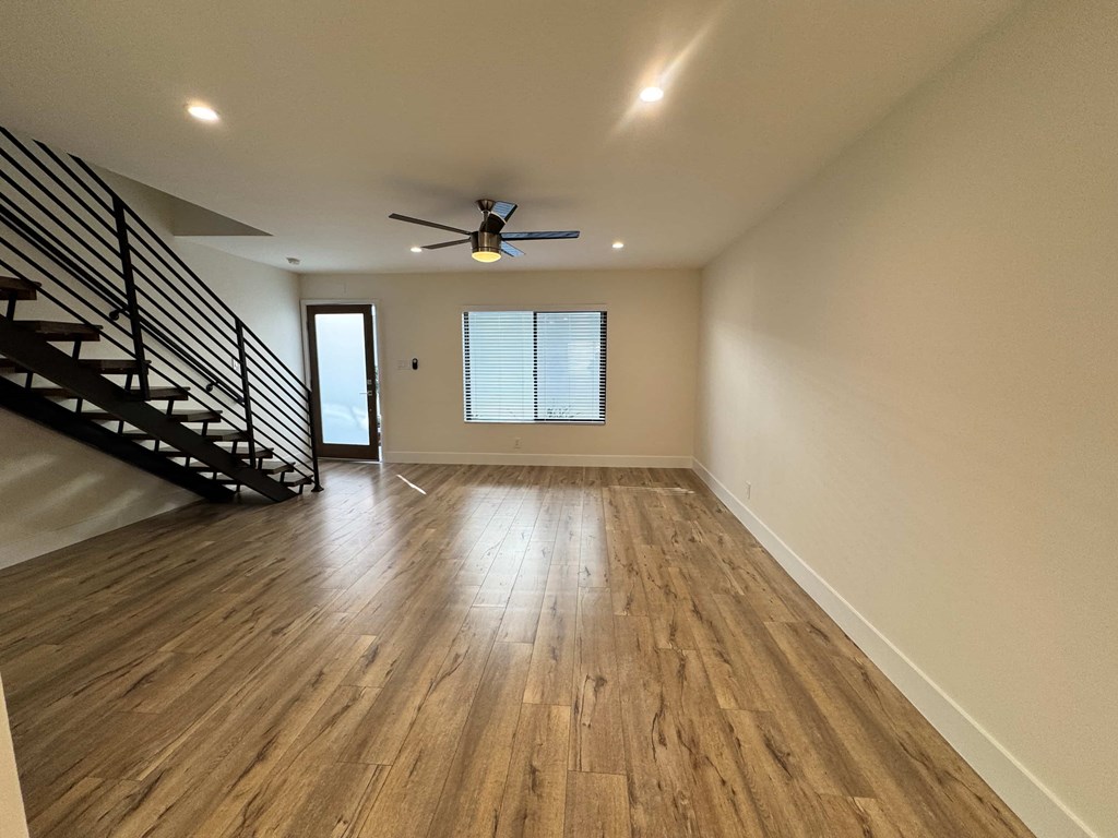 A room with wooden flooring and a ceiling fan.