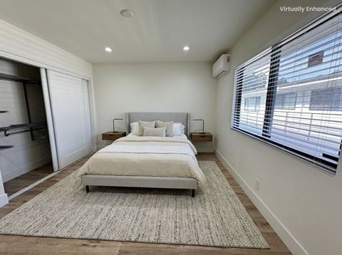 A bedroom with a large bed and a rug on the floor.