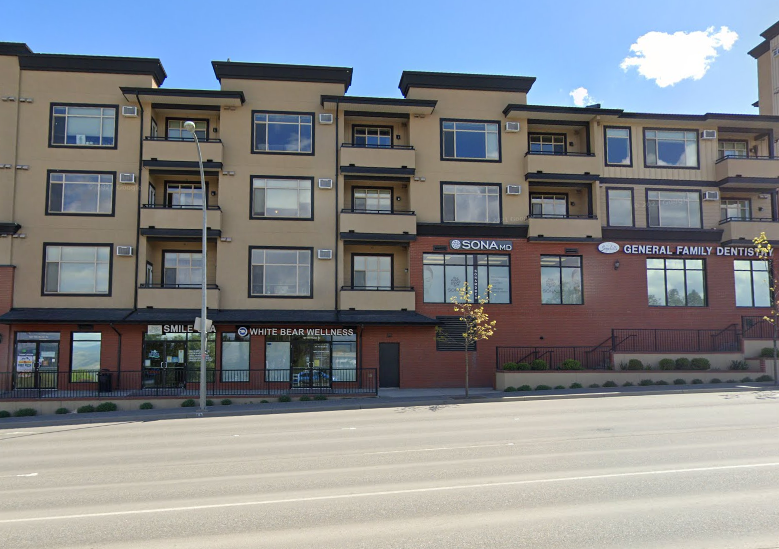 A multi-story apartment building with a dental office in front.