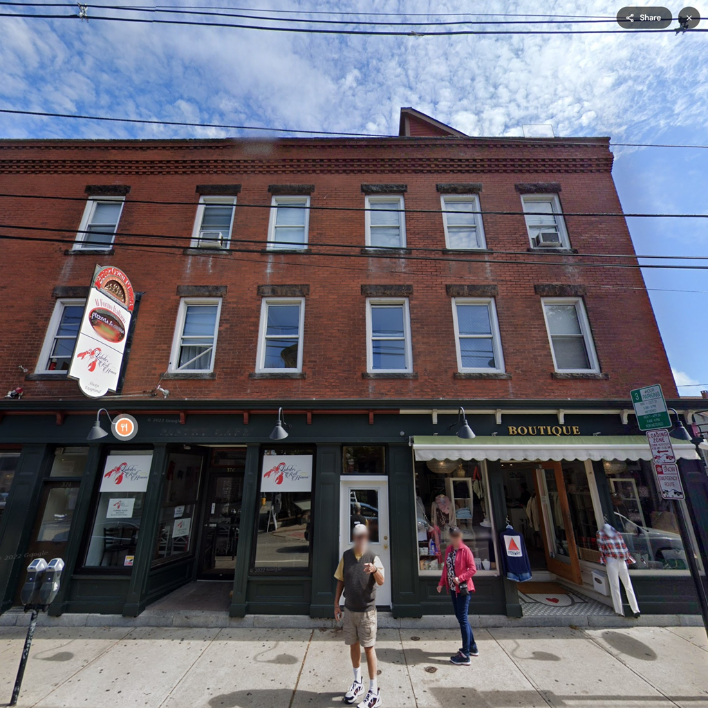A red brick building with a green awning and a sign that says "Restaurant".