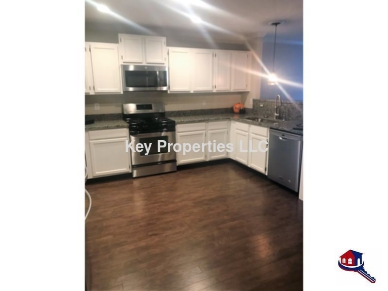 A kitchen with a stove top oven and a microwave built into the cabinetry.