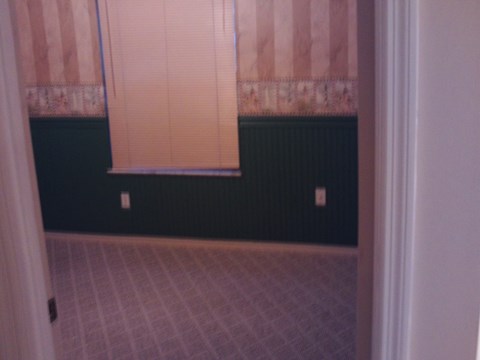A room with a window and a tiled floor.