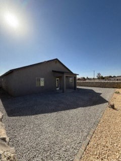 A small building with a gravel driveway in front.