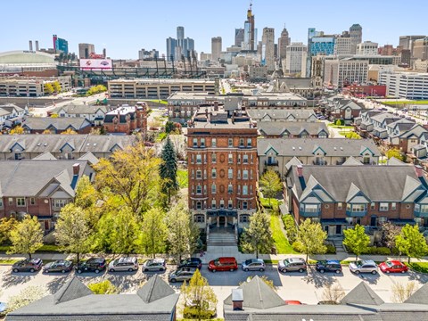 A view of a residential area with a large building in the center and a city skyline in the background.
