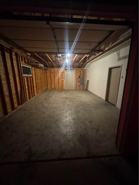 A room with a wooden wall and a door is shown.