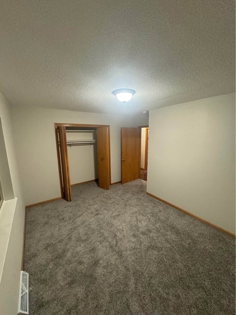 A room with a carpeted floor and a ceiling light.