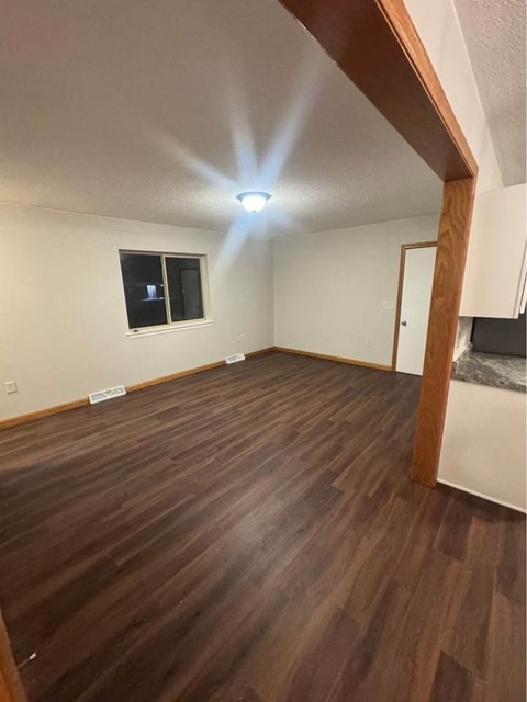 A room with wooden flooring and a window.