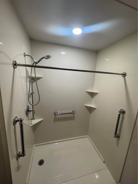 A white bathroom with a walk in shower.