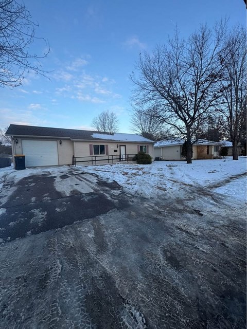 A house with a driveway covered in snow.