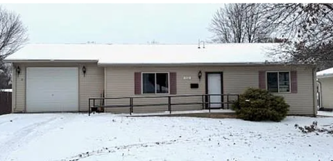 A house with a snow-covered ground and a grey sky.
