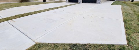 A white concrete walkway leads to a building.