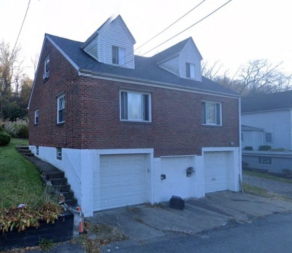 A two-story brick house with a white garage door.