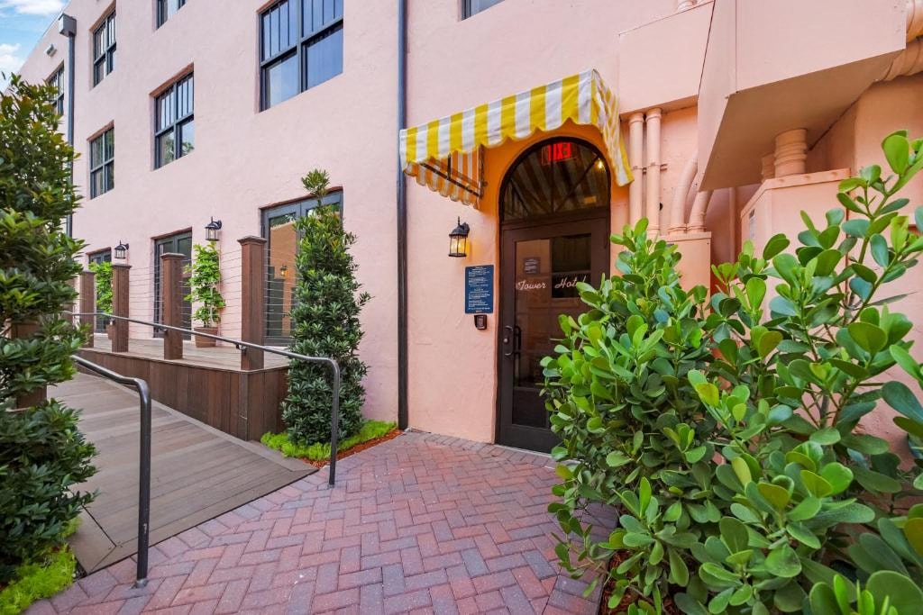 A building with a red brick walkway and a yellow awning.
