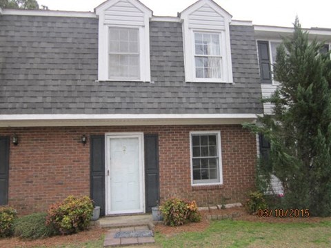 A house with a white door and two windows.