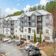 Apartment building with cars parked in front.