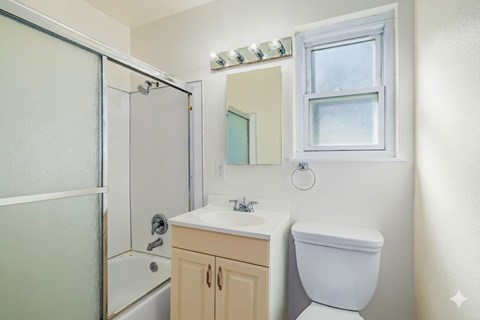 A white toilet sits next to a sink in a small bathroom.