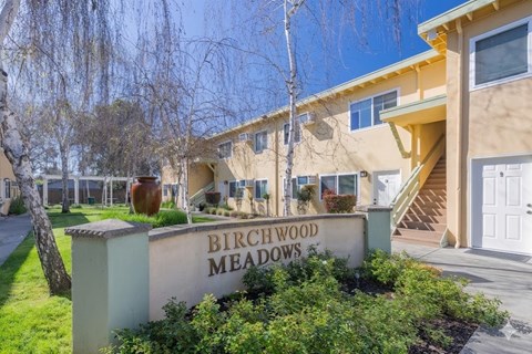 A sign that says Birchwood Meadows in front of a building.
