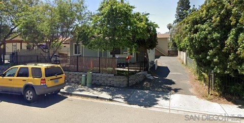 A yellow car is parked on the side of a street.