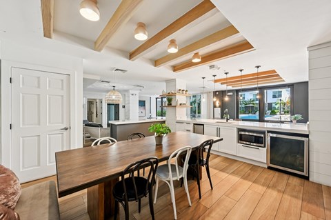 A modern kitchen with a wooden table and chairs.