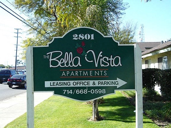 A sign for Bella Vista Apartments with a phone number for the leasing office and parking.