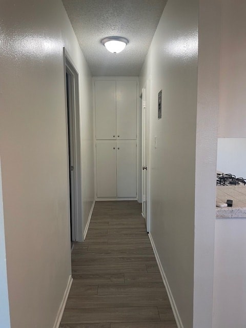 A long hallway with white walls and wood flooring.