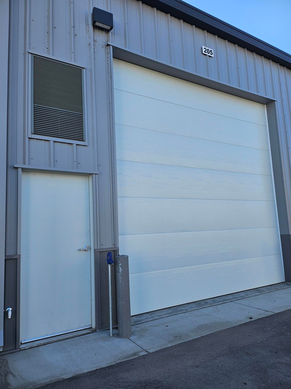 A garage door with the number 205 on the side of the building.