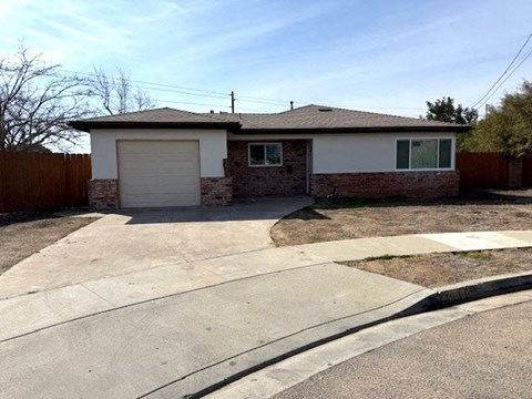 A house with a garage and a driveway in front.